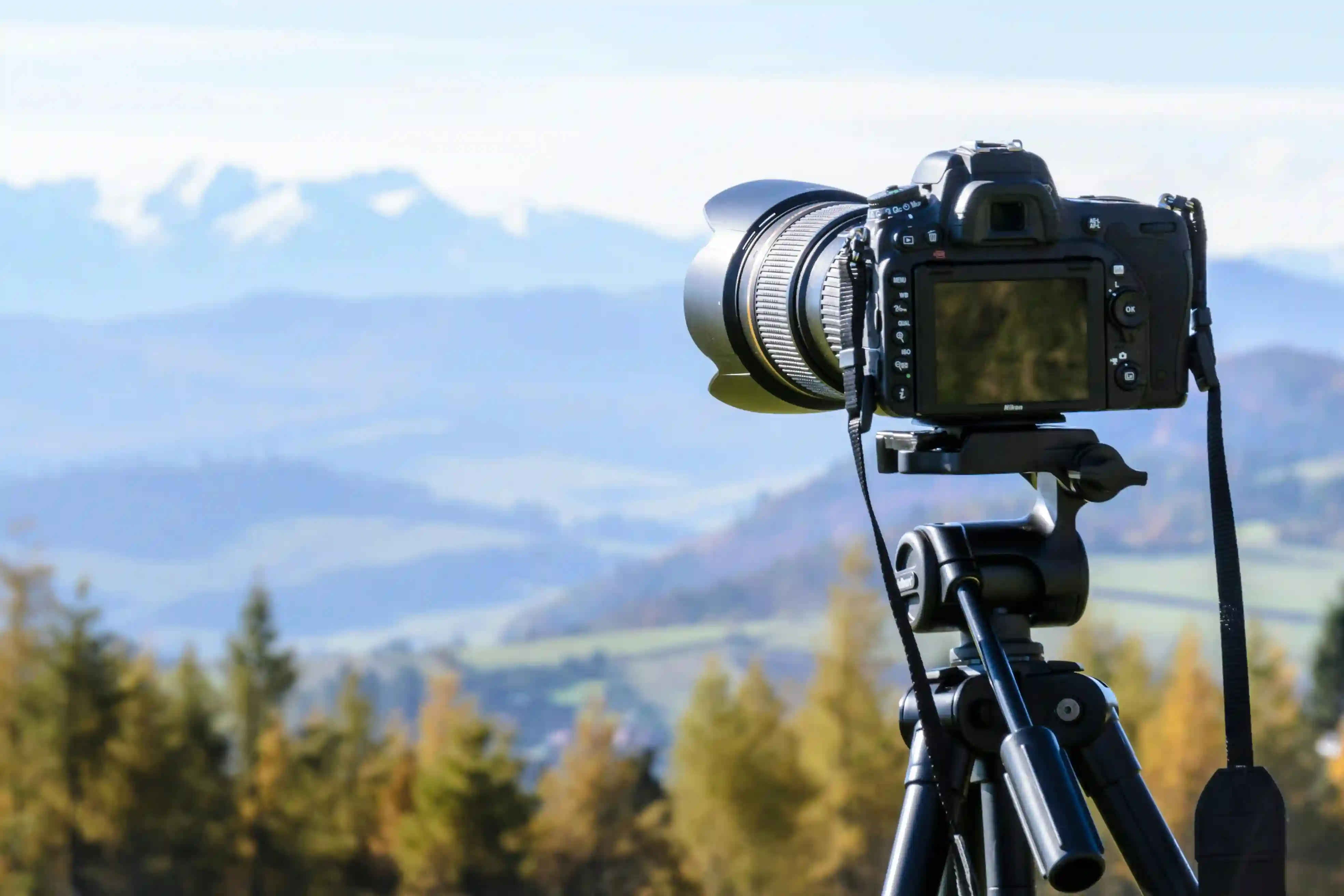 Professional DSLR camera tripod capturing mountain landscape